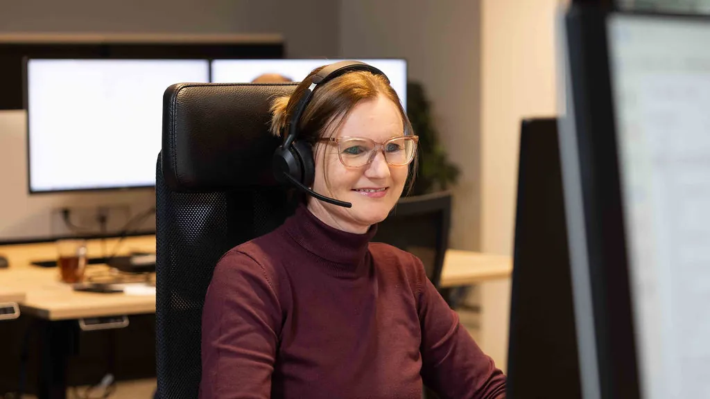 Een collega aan de servicedesk met een headset op